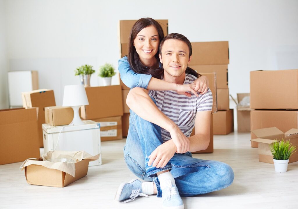 a couple surrounded by boxes in a room