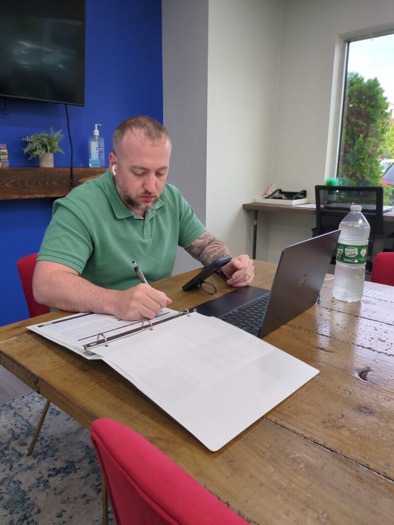 Frank Bergen working through paperwork at the conference table in the Pinnacle Team office on Willowbrook Road