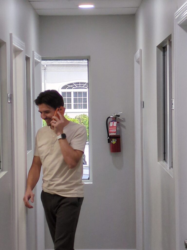 Simon Umanoff on a call in the hallway at the Pinnacle Team office on Willowbrook Road