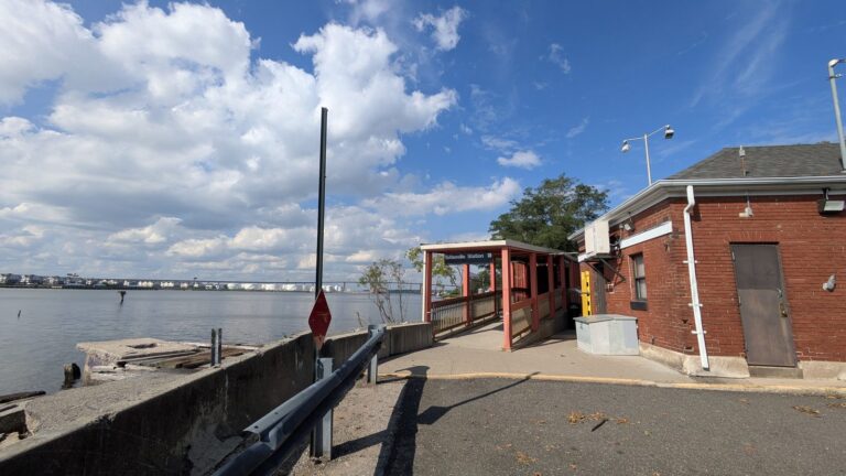 Red brick building at Tottenville station with Raritan Bay beyond the sea wall