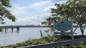 The Welcome to Tottenville sign at Bentley Landing, with Raritan Bay behind it